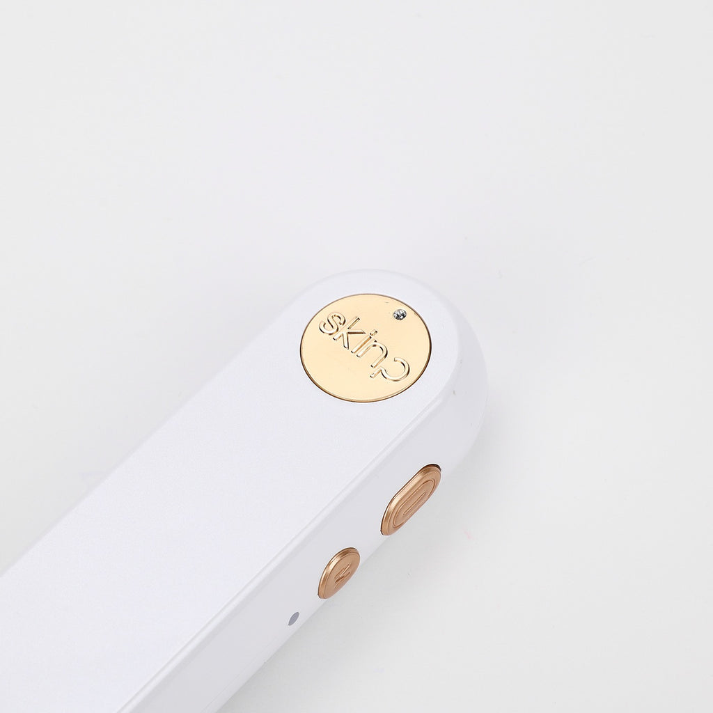 Close-up of a gold 'skim' logo on a white background